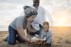 Happy African family having fun on the beach during summer vacation