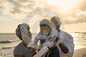 Happy African family having fun on the beach during summer vacation