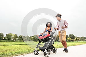 Happy African family having fun together in public park - Afro mother and father with their daughter enjoying time together