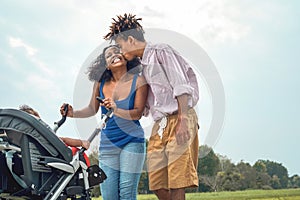 Happy African family having fun together in public park - Afro mother and father with their daughter enjoying time together