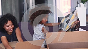 Happy african family having fun unpacking boxes on moving day