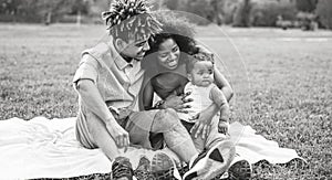 Happy African family having fun during the weekend in public park - Mother and father playing with their daughter outdoor