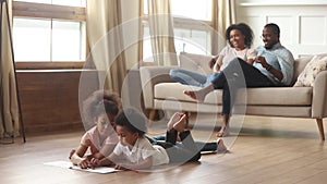 Happy african family with kids in living room leisure activities