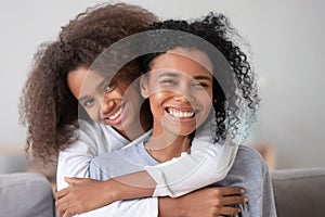 Happy african family mother and teen girl embracing mom, portrait