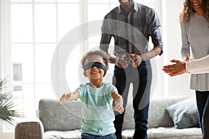 Happy African family playing hide and seek at home