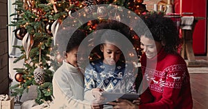 Happy African family using tablet buying Christmas gifts on internet
