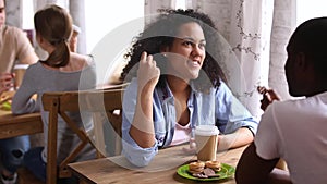 Happy african girl enjoying date with black guy in cafe