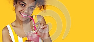 Happy african girl holding drink look at camera isolated on yellow background