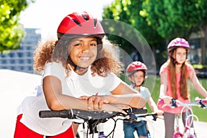 Happy African girl riding bicycle in summer city