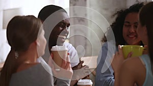 Happy african guy having fun laughing talking to multiracial friends