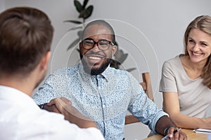 Happy african hr recruit handshake hire candidate at job interview