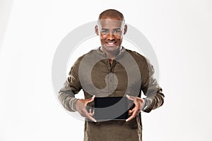 Happy african man showing blank tablet computer screen