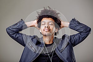 Happy african man smiling listening to music in headphones. White background.