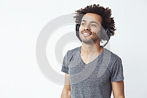 Happy african man smiling listening to music in headphones. White background.