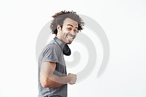 Happy african man smiling looking st camera showing tongue over white background.