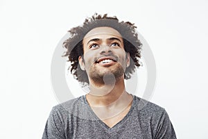 Happy african man smiling looking up over white background.