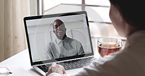 Happy african man talks with woman makes videocall on laptop