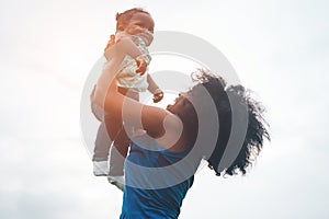 Happy african mother playing with her daughter outdoor - Afro mum and child having fun together - Family, happiness and love