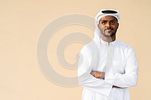 Happy African Muslim man wearing religious clothing an scarf with arms crossed