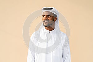 Happy African Muslim man wearing religious clothing an scarf while thinking