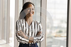 Happy African professional woman in casual shirt posing in office