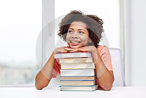 Happy african student girl with books at home