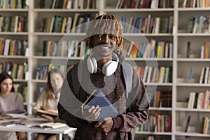 Happy African student guy pose in university library