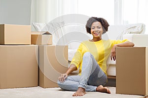 Happy african woman with cardboard boxes at home