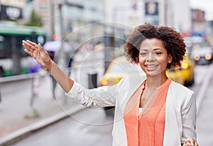 Happy african woman catching taxi