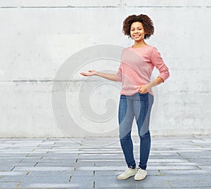 Happy african woman holding something imaginary