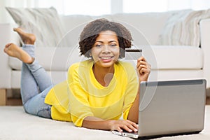 Happy african woman with laptop and credit card