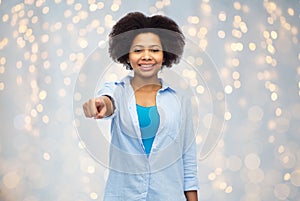 Happy african woman pointing finger to you