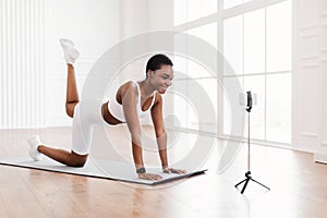 Happy African Woman In Sportswear Doing Donkey Kicks Exercise