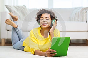 Happy african woman with tablet pc and headphones