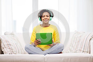 Happy african woman with tablet pc and headphones
