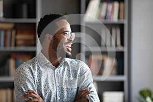 Happy African worker looking in distance thinking of career growth