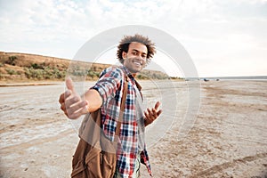 Happy african young man inviting you to go with him