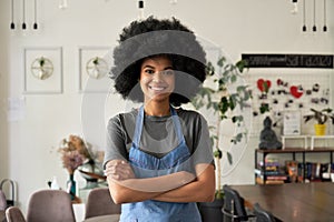 Happy African young woman cafe small business owner standing arms crossed.