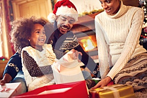 Happy Afro-American family opening Christmas presents photo