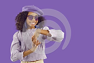 Happy Afro American girl in trendy purple outfit posing in modern fashion studio