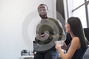 Happy afro american guy chatting with a female colleague