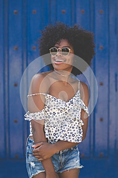 Happy afro american woman on blue background looking away