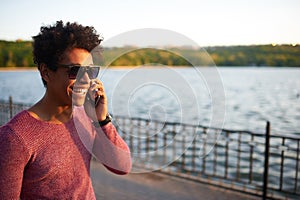 Happy afro american young man talking on phone