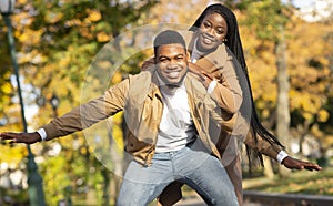 Happy afro couple having fun on date in autumn park