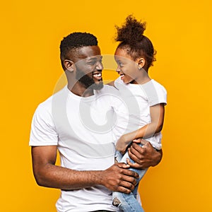 Happy afro daddy embracing with his cute baby daughter