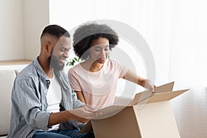 Happy afro man and woman customer unbox package order photo