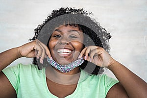 Happy Afro woman portrait - African girl wearing face mask smiling in front of camera