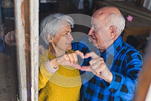 Happy aged couple concept. Together on retirement. Caucasian senior couple showing heart sign with their fingers to the