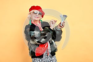 Happy aged woman holding money, counting it, Emotion and feelings concept.