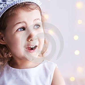 Happy amazed female kid emotion. Suprised child portrait. Young girl imagine